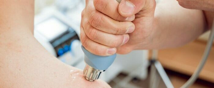 Shock wave therapy. The magnetic field, rehabilitation. Physiotherapist doctor performs surgery on a patient's shoulder